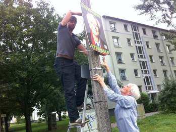 Plakateaufhängen in Prenzlauer Berg-Ost